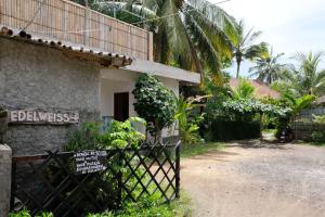 a gate in front of a house with a sign at Edelweiss Homestay in Kuta Lombok