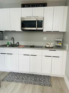 a kitchen with white cabinets and a microwave at Casita Guayaba in Miami