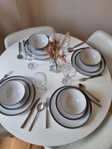 a white table with black and white plates and silverware at UK Chaps Retreat: Balcony Apartment in London