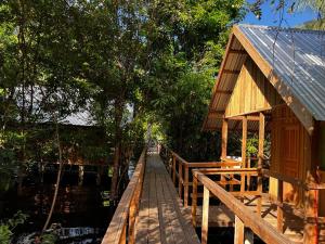 una pasarela de madera que conduce a un edificio junto al agua en Amazônia LODGE Exxperience, en Manaus