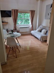 a living room with a table and a bed at UK Chaps Retreat: Balcony Apartment in London