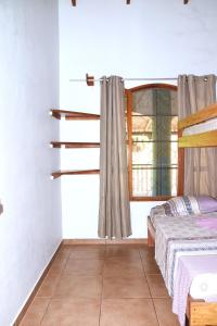 um quarto com uma cama e uma janela em Osa House - Drake Bay em Drake