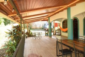 a patio with tables and chairs and a wooden ceiling at Osa House - Drake Bay in Drake