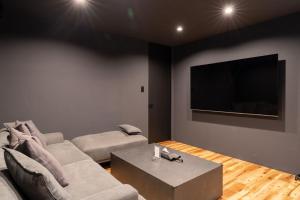 a living room with a couch and a flat screen tv at THE SECOND Nasukogen Forest House in Nasu-yumoto
