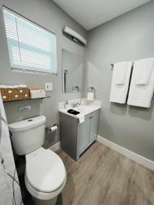 a bathroom with a white toilet and a sink at Casita Guayaba in Miami