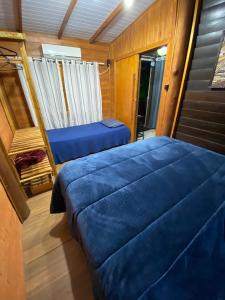 1 Schlafzimmer mit 2 blauen Betten in einem Boot in der Unterkunft Cabanas dos Sonhos Barra de Ibiraquera in Imbituba
