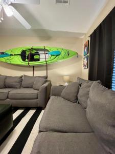 a living room with a couch and a kayak on the wall at Bayou and Beyond: The perfect stay in Monroe