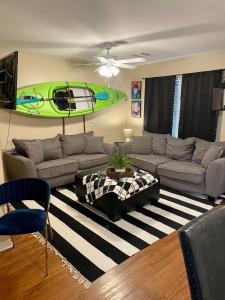 a living room with a couch and a surfboard on the wall at Bayou and Beyond: The perfect stay in Monroe