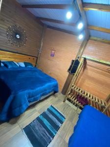 ein Schlafzimmer mit einem blauen Bett in einem Zimmer in der Unterkunft Cabanas dos Sonhos Barra de Ibiraquera in Imbituba