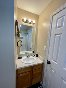 a bathroom with a sink and a mirror at Bayou and Beyond: The perfect stay in Monroe
