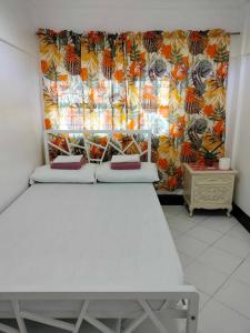 a room with two beds in front of a curtain at Sassy's Place in Baguio
