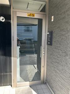 un ingresso a un edificio con porta a vetri di One Point Five a Tokyo