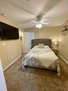 a bedroom with a bed and a flat screen tv at Bayou and Beyond: The perfect stay in Monroe