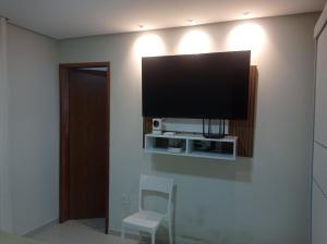 a flat screen tv on a wall in a room at Residência completa e com garagem in Garanhuns