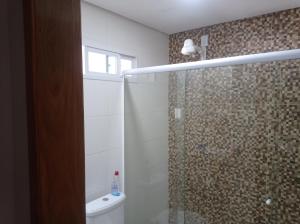 a bathroom with a shower and a toilet and a window at Residência completa e com garagem in Garanhuns +28 photos
