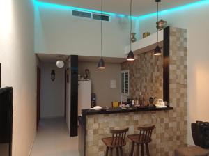 a kitchen with a counter and some stools at Residência completa e com garagem in Garanhuns