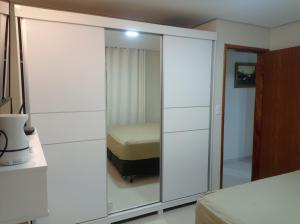 a bedroom with a mirrored closet with a bed in it at Casa de Esquina Nova in Garanhuns
