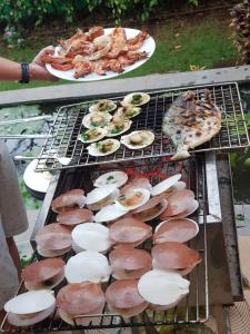 uma grelha com um monte de cogumelos e comida. em Oceanami Resort Sea View em Long Hai