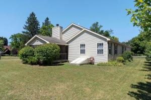 a white house with a porch and a yard at Delight: Bold & Bougie! Sleeps 12! Downtown Boyne in Boyne City