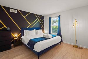 a bedroom with a bed with a blue and yellow wall at Delight: Bold & Bougie! Sleeps 12! Downtown Boyne in Boyne City