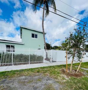 a white fence in front of a white house at Casita Guayaba in Miami