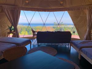 伊東市にあるIzu coco dome tent C - Vacation STAY 87884vのソファ、景色を望む大きな窓が備わる客室です。