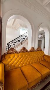 Sofá marrón en una habitación con escalera en Villa Istanaku, en Tegalharendong