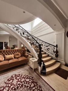 sala de estar con sofá y escalera en Villa Istanaku, en Tegalharendong