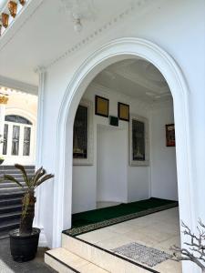 un arco en un edificio blanco con una maceta en Villa Istanaku, en Tegalharendong