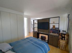 a bedroom with a bed and a flat screen tv at Modern loft, view-town-La Candelaria neighborhood in Bogotá