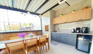 a kitchen with a table and some chairs in it at Cobertura Palmas in Governador Celso Ramos +1 photo