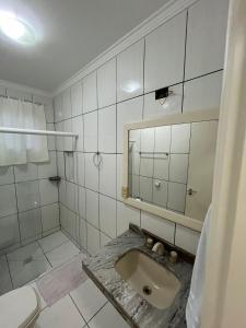 a bathroom with a sink and a mirror at Espaço de praia acolhedor para família e pets in Matinhos