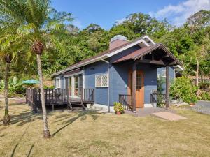 une maison bleue avec une véranda et un palmier dans l'établissement Villa AdanRose Amami - Vacation STAY 06112v, à Amami