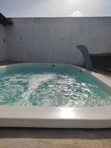 uma banheira cheia de água verde num quarto em Casa com piscina Forte Orange- Itamaracá em Itamaracá