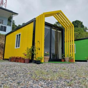 a yellow tiny house with a large window at SF Homestay in Kampong Kundassan