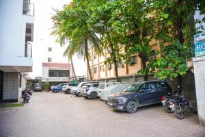 een rij auto's geparkeerd op een parkeerplaats bij Hotel Sachidanand in Shirdi