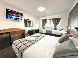 Mackay Resort Motel في ماكاي: غرفة فندقية بسريرين وتلفزيون بشاشة مسطحة