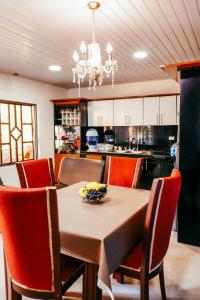 a dining room with a table and chairs and a kitchen at CASA GOMEZ in Leticia