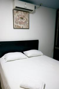 a white bed with two pillows in a bedroom at CASA GOMEZ in Leticia