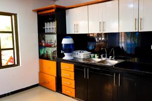 a kitchen with black and white cabinets and a sink at CASA GOMEZ in Leticia