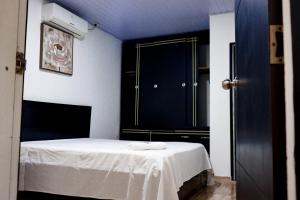 a bedroom with a bed and a black cabinet at CASA GOMEZ in Leticia