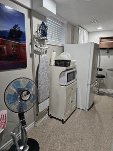 una cucina con frigorifero, tavolo e forno a microonde di Amazing cozy fully private studio a London