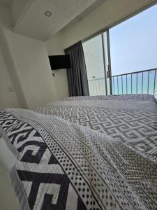 a bedroom with a bed and a large window at Apartamento Torres gemelas in Acapulco +19 photos