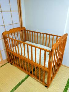cuna de madera en una esquina de habitación en Shinsaibashi East, en Osaka