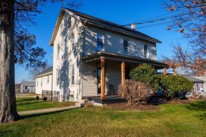 an old white house with a porch at Very Cozy, 2 Bedroom Farmhouse Apartment 2nd FL in Lancaster