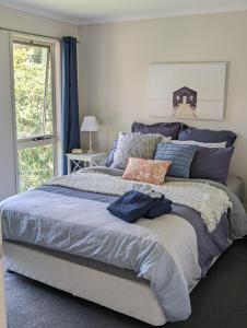 Un dormitorio con una cama grande y una ventana en Twin Beaches Retreat Cowes, en Cowes