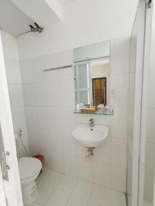 La salle de bains blanche est pourvue de toilettes et d'un lavabo. dans l'établissement Hoian Old Town Hostel, à Hội An