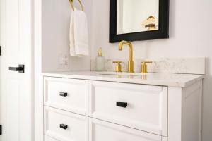 ein weißes Badezimmer mit einem Waschbecken und einem goldenen Wasserhahn in der Unterkunft Very Cozy, 2 Bedroom Farmhouse Apartment 2nd FL in Lancaster + 32 Fotos