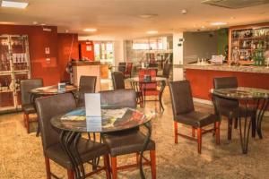 a restaurant with tables and chairs and a counter at Flat Pampulha orla prox Mineirão in Belo Horizonte