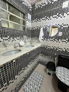 a bathroom with black and white tiled walls at Casa com 03 quartos proximo a rodoviaria in Uruguaiana